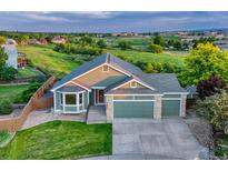 Inviting two-story home with a three-car garage and lush, green surroundings at 1838 Mountain Daisy Ct, Highlands Ranch, CO 80129