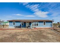 Charming blue home featuring an inviting patio and a well-maintained landscape at 16491 County Road 32, Platteville, CO 80651