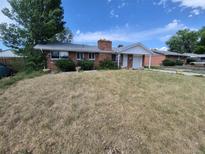 Charming brick home with a covered entrance and a well-maintained front yard under a bright sky at 12063 E Arizona Dr, Aurora, CO 80012