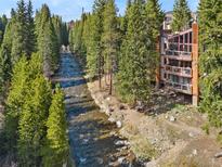 Riverside condo with balconies and ample natural light, surrounded by lush greenery at 805 Columbine Rd # 202, Breckenridge, CO 80424