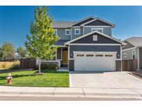 Attractive two-story home with a two-car garage, a green lawn, and a bright, inviting yellow front door at 7958 Tejon St, Denver, CO 80221