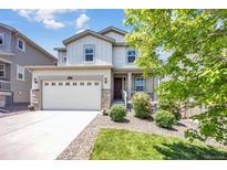 Charming two-story home featuring a manicured front lawn, complemented by a two-car garage and stone accents at 3325 Umber Cir, Castle Rock, CO 80109