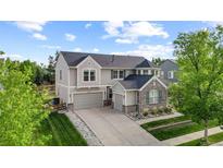 Beautiful two-story home featuring a well-manicured lawn, stone accents, and a two-car garage at 6040 Virgil St, Arvada, CO 80403
