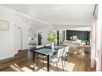 Open dining room with black table and natural light at 3407 W Arkansas Ave, Denver, CO 80219