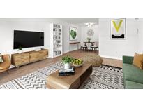Cozy living room adjacent to dining area, showcasing modern decor, comfortable seating, and a stylish rug at 7755 E Quincy Ave # 203A2, Denver, CO 80237