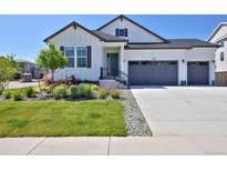 Charming home with modern white siding, dark trim, and a two-car garage, plus a lovely manicured front yard at 1160 Spencer Pl, Erie, CO 80026