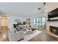 Bright living room with modern furnishings, fireplace and a sliding glass door to the balcony at 800 Pearl St # 204, Denver, CO 80203