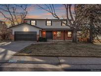 Brick two-story house with attached garage, landscaping, and a tree-lined street at 8736 E Easter Ave, Centennial, CO 80112