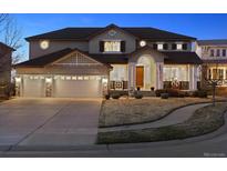 Beautiful two-story home featuring a three-car garage, well-maintained lawn, and inviting front porch at 1015 Graland Pl, Highlands Ranch, CO 80126