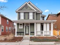 Charming two-story home with a covered porch, white columns, a well-kept lawn, and beautiful curb appeal at 2768 Florence St, Denver, CO 80238