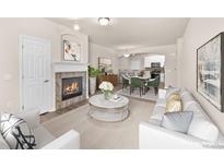 Bright, staged living room featuring a fireplace, modern decor, and open layout to the dining area and kitchen at 9397 Las Ramblas Ct # D, Parker, CO 80134