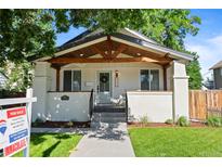 Charming home with an inviting front porch featuring exposed timber and a well-maintained front yard at 5543 S Prince St, Littleton, CO 80120