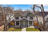 Charming two-story duplex with white siding, black trim, green accents, and a well-manicured front lawn at 2432 Ames St, Edgewater, CO 80214