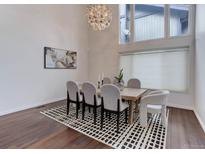 An elegant dining room with wood floors, a unique chandelier, and modern decor at 10226 E Fair Pl, Englewood, CO 80111