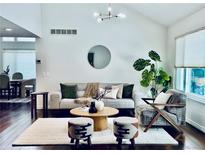 Bright living room featuring stylish decor, modern lighting, and dark hardwood floors at 10226 E Fair Pl, Englewood, CO 80111