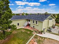 Charming home with light green siding, new roof, landscaped yard, and white stairway entrance at 41504 Vista Ridge, Parker, CO 80138