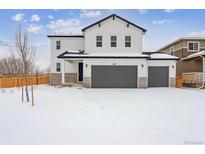 Two-story house with gray siding and a two-car garage in a snowy landscape at 4487 Boone Cir, Brighton, CO 80601