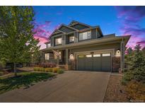 Charming two-story home with well-maintained landscaping, inviting porch, and two car garage at 26004 E Elmhurst Pl, Aurora, CO 80016