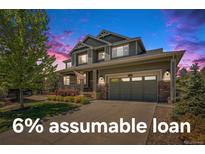 Charming two-story home with a well-manicured lawn, inviting porch, and attached two-car garage at 26004 E Elmhurst Pl, Aurora, CO 80016