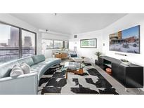 Bright living room with city views, modern furnishings, and a unique black-and-white patterned rug at 100 Park W Ave # 1606, Denver, CO 80205