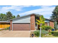 Charming single Gathering home with well-kept front lawn, attached garage and brick facade at 1430 Mount Evans Dr, Longmont, CO 80504