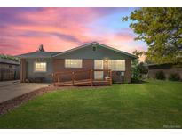 Charming brick home with a wooden ramp and well-maintained lawn against a beautiful sunset sky at 717 E 4Th Ave, Longmont, CO 80504