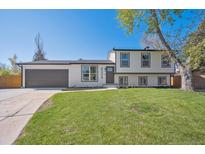 Charming two-story home boasts fresh landscaping and a large, well-maintained front lawn at 8004 S Field St, Littleton, CO 80128