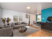 Bright living room with hardwood floors, neutral tones, and stylish decor create an inviting living space at 6903 W 52Nd Pl, Arvada, CO 80002
