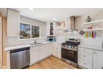 Bright kitchen features white cabinets, stainless steel appliances, and a window with a view at 3237 N Milwaukee St # 8, Denver, CO 80205
