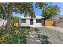 Charming home featuring white siding, black trim, and a landscaped front yard with mature trees providing shade at 1670 S Quieto Ct, Denver, CO 80223