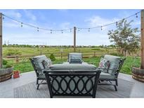 Inviting outdoor patio area with comfortable seating and string lights, perfect for relaxing and entertaining with a beautiful view at 5864 Turnstone Pl, Castle Rock, CO 80104