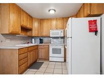 Cozy kitchen featuring wooden cabinets, neutral countertops, and essential appliances at 710 S Clinton St # 1A, Denver, CO 80247