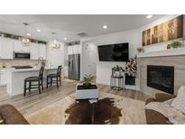 Bright living room featuring a fireplace, a mounted TV, and an open floor plan that connects to the kitchen at 8132 Mt Harvard Rd, Littleton, CO 80125