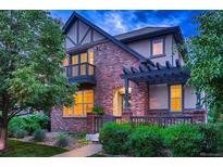 Charming two-story brick home with a cozy front porch and well-maintained landscaping at 237 Dayton St, Denver, CO 80230