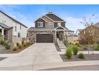 Beautiful two-story home with a stone and brown wood exterior and well-manicured front yard at 4408 Riviera Ct, Aurora, CO 80019