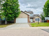 Charming two-story home featuring a large garage, manicured lawn and inviting entrance at 6188 Viewpoint Ave, Firestone, CO 80504