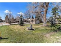 Charming home with a well-manicured front yard and mature trees at 10601 W 78Th Ave, Arvada, CO 80005