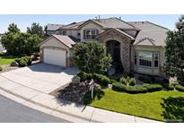 Charming home featuring a stone archway, lush landscaping, and a well-maintained front yard at 11911 E Lake Cir, Greenwood Village, CO 80111
