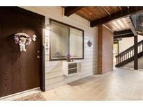 Charming entrance with a decorative wreath on a wood door and a window with a small air conditioning unit at 14806 E 2Nd Ave # 104G, Aurora, CO 80011