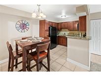 Bright kitchen featuring tile floors, dark cabinets, and a black refrigerator, open to the dining area at 430 Zang St # 4-103, Lakewood, CO 80228