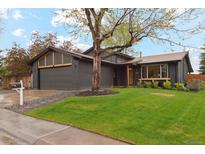 Charming single Gathering home with a well-manicured lawn and lovely mature tree in the front yard at 7719 Everett Way, Arvada, CO 80005