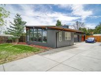 Modern gray home with a concrete driveway, large picture windows, and a well-maintained front yard at 450 Yukon St, Lakewood, CO 80226