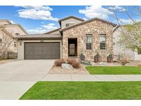Charming stone-accented exterior with well-manicured lawn and two car garage at 2280 S Norse St, Denver, CO 80228