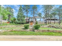 Charming gray home with stone accents and mature trees in a picturesque setting at 350 Tower Hill Cir, Golden, CO 80401