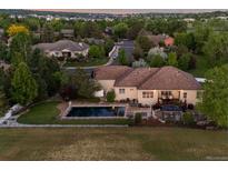 Expansive backyard featuring a pool, hot tub, covered patio and views of the manicured yard at 5653 Yank St, Arvada, CO 80002