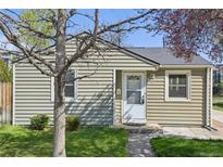 Charming single-story home with light-green siding, a well-manicured lawn, and a welcoming front door at 6819 Reno Dr, Arvada, CO 80002