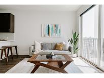 Bright living room featuring a comfortable sofa, modern art, and a coffee table, creating a cozy and inviting space at 1898 S Bannock St # 510, Denver, CO 80223