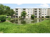 Beautiful exterior view of condo building, including a pond with a fountain and well-manicured landscaping at 7780 W 38Th Ave # 203, Wheat Ridge, CO 80033