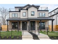 Modern townhouse with a black metal fence, metal roof, and a low-maintenance landscaped front yard at 2520 S Cherokee St, Denver, CO 80223
