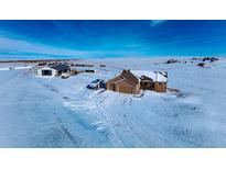 Aerial view of a house, barn, and expansive snowy land at 7295 Sunset Ave, Elizabeth, CO 80107